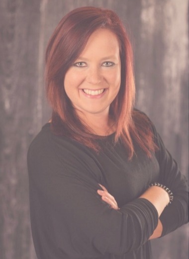 Candice Ullery, a woman with red hair, smiling for the camera.