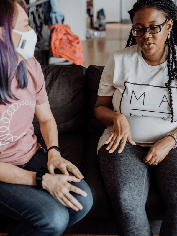 Two women having a conversation on a couch, captured for a blog.