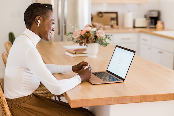 Happy woman talks to someone on a computer.